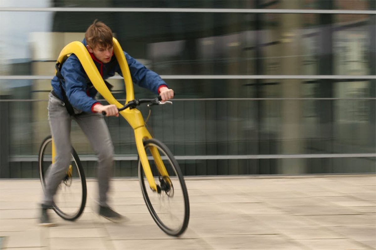 man strapped to yellow bike.