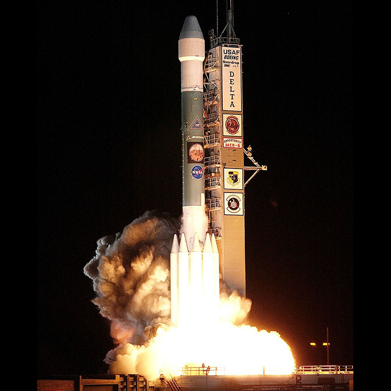 Rocket on the launchpad at night, thrusters beginning to fire.