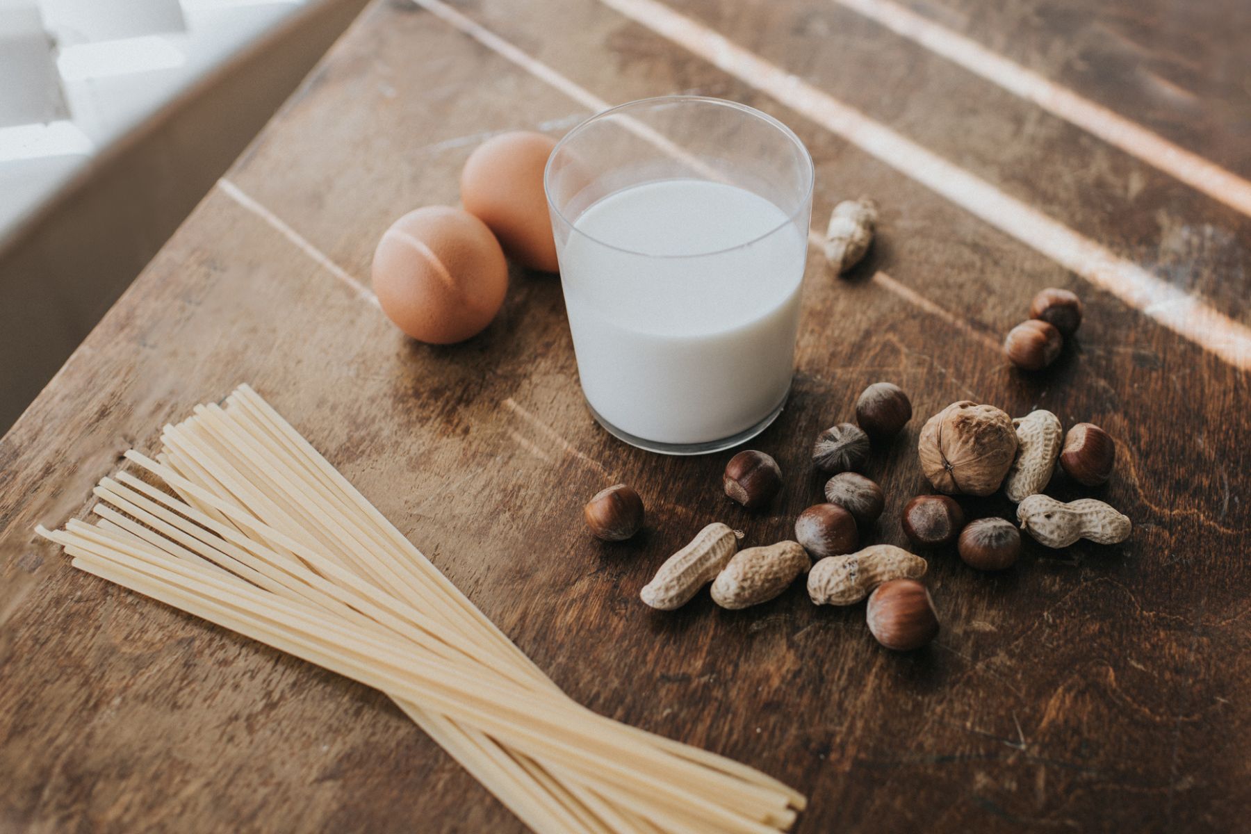 Milk, pasta, eggs and nuts on a table