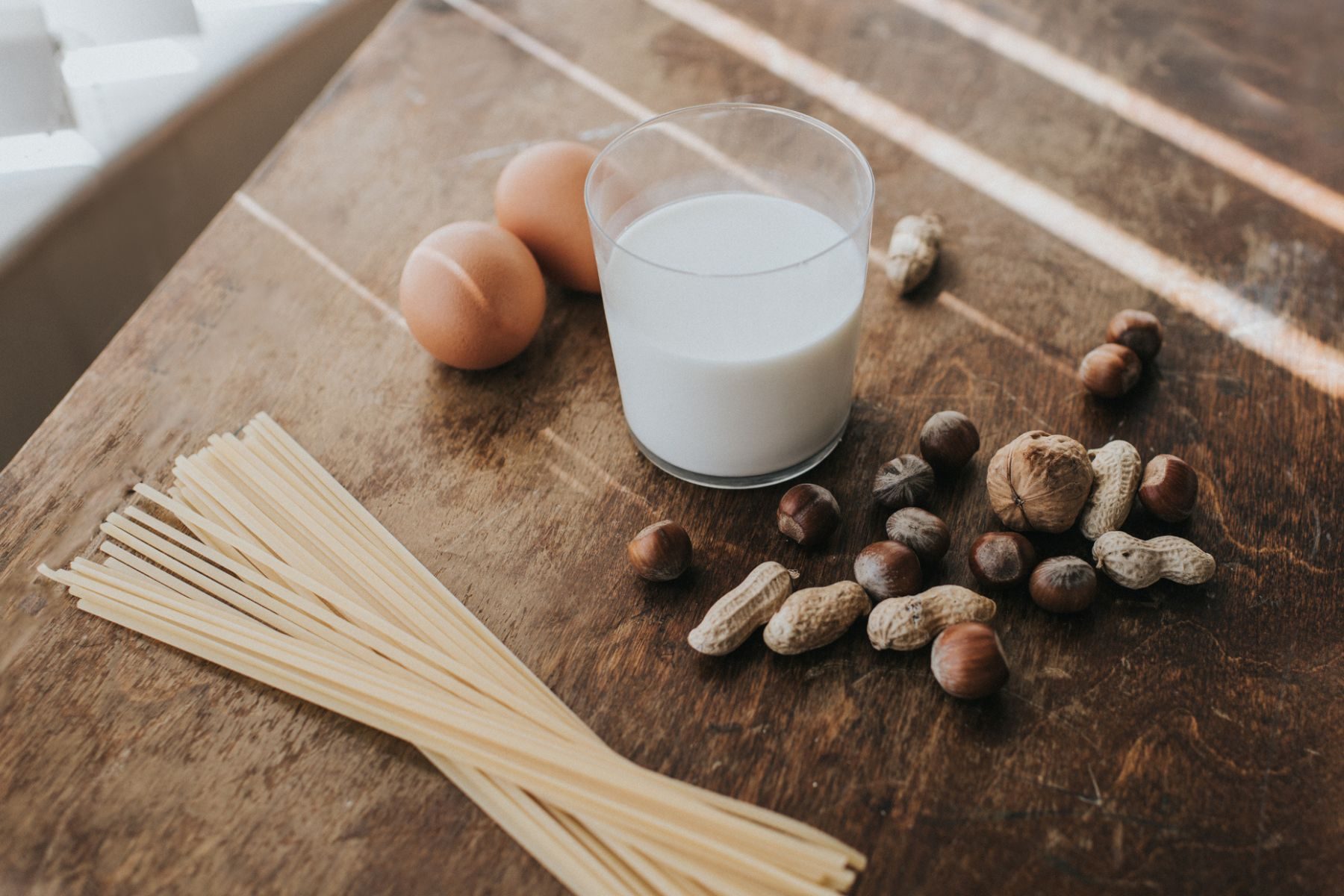 Milk, pasta, eggs and nuts on a table