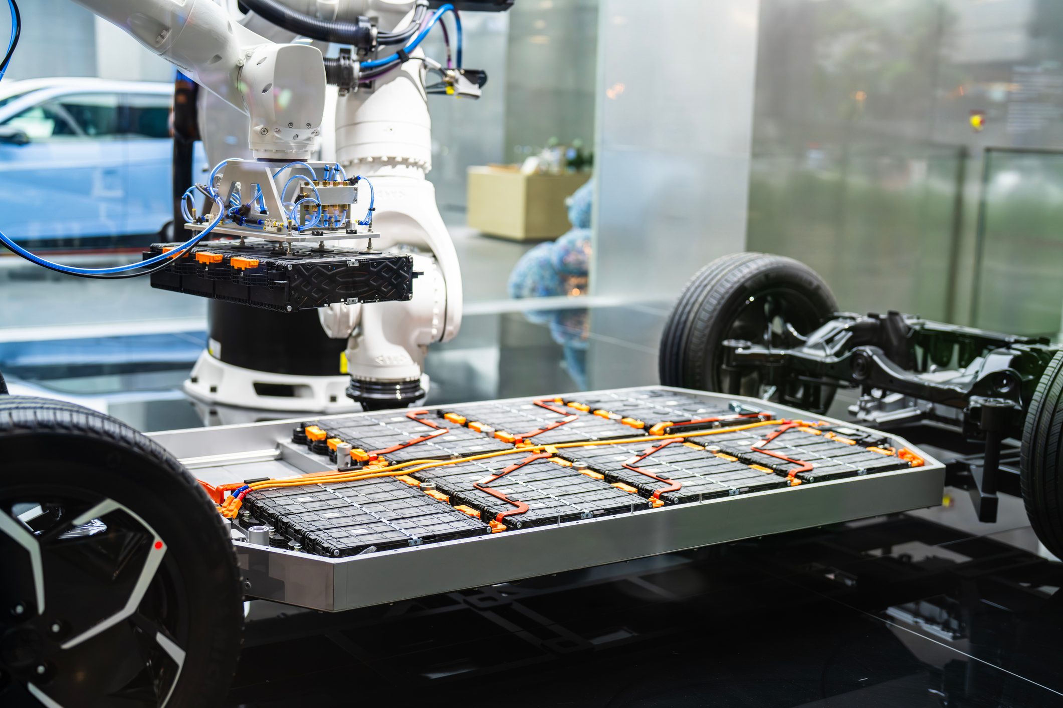 Advanced robotic machinery operates to assemble components of an electric vehicle, specifically focusing on the battery unit, highlighting progress in automation technologies for eco-friendly transportation innovations.