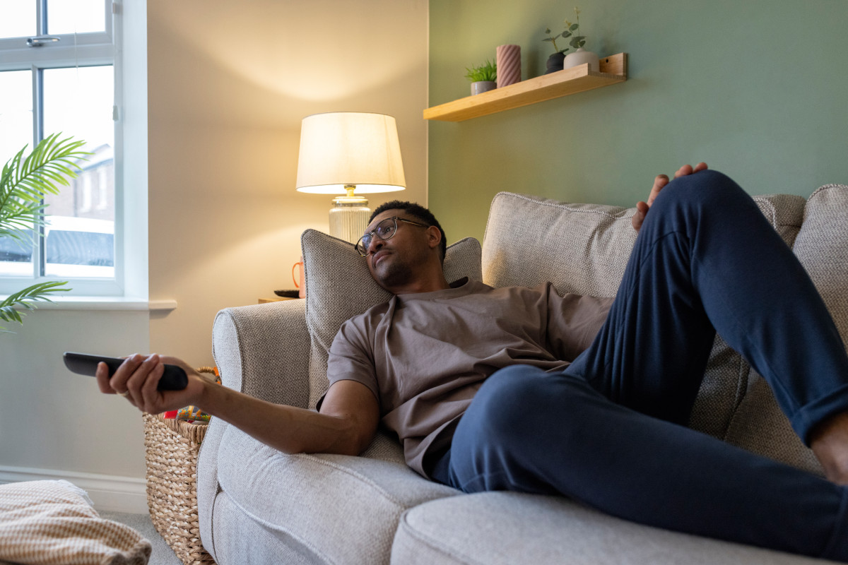 A shot of a mid-adult male taking a break in the living room of his home