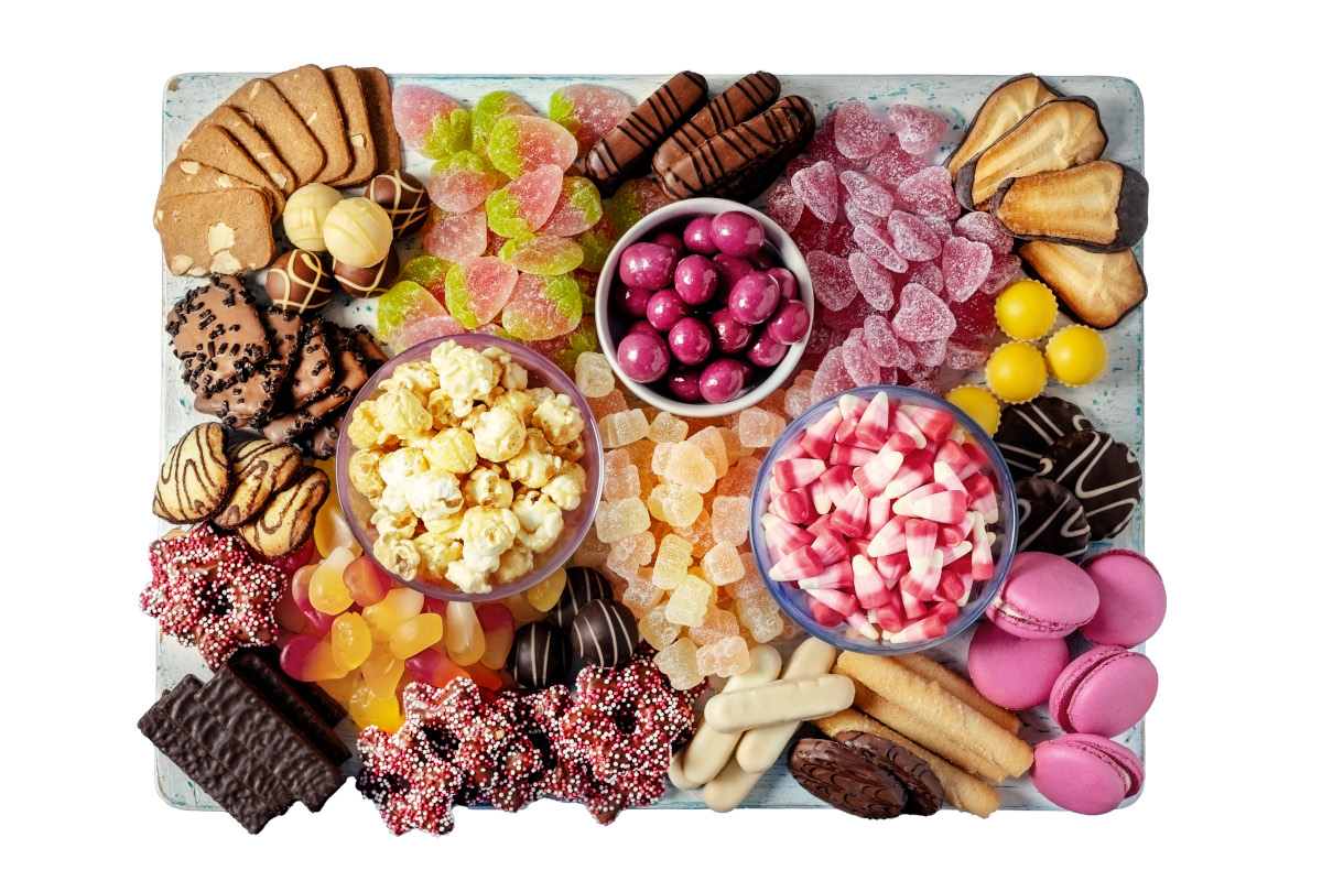 A board covered in sweets, biscuits, chocolate and popcorn