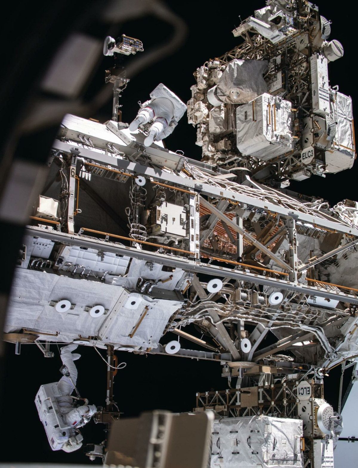 Astronauts Andrew R Morgan (top) and Luca Parmitano (below) making thermal repairs on the Alpha Magnetic Spectrometer, a dark matter detector 