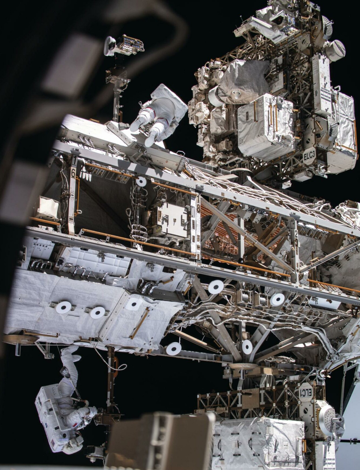 Astronauts Andrew R Morgan (top) and Luca Parmitano (below) making thermal repairs on the Alpha Magnetic Spectrometer, a dark matter detector