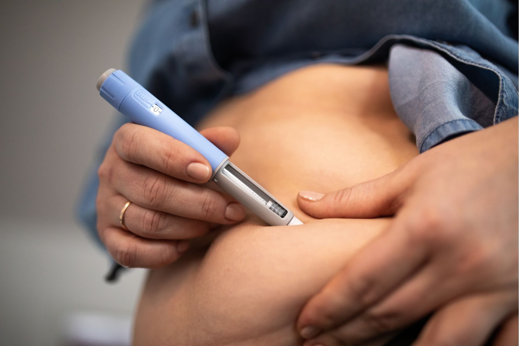 Someone injecting their abdomen with semaglutide