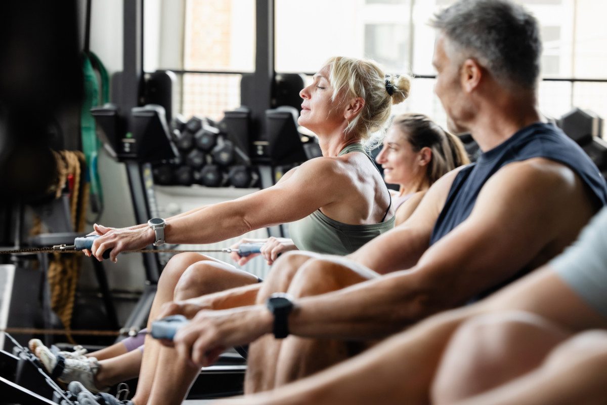 A group of people on rowing machines in a gym