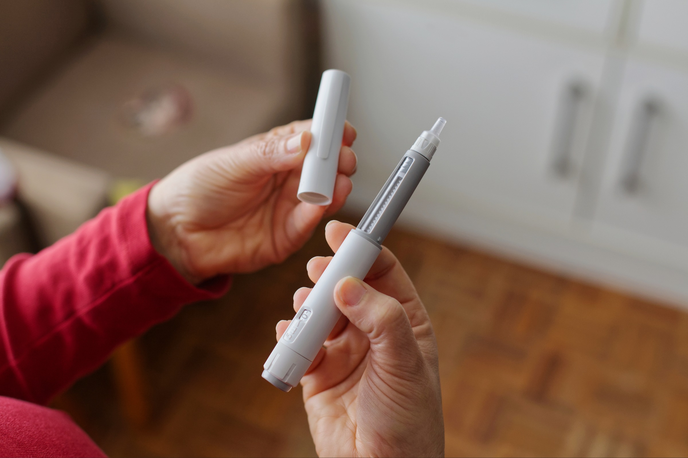 Person holding GLP-1 injection.