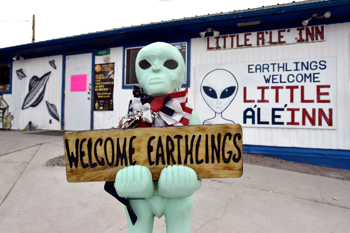 An alien-like statue displays a sign welcoming guests to the Little A'le' Inn restaurant and gift shop