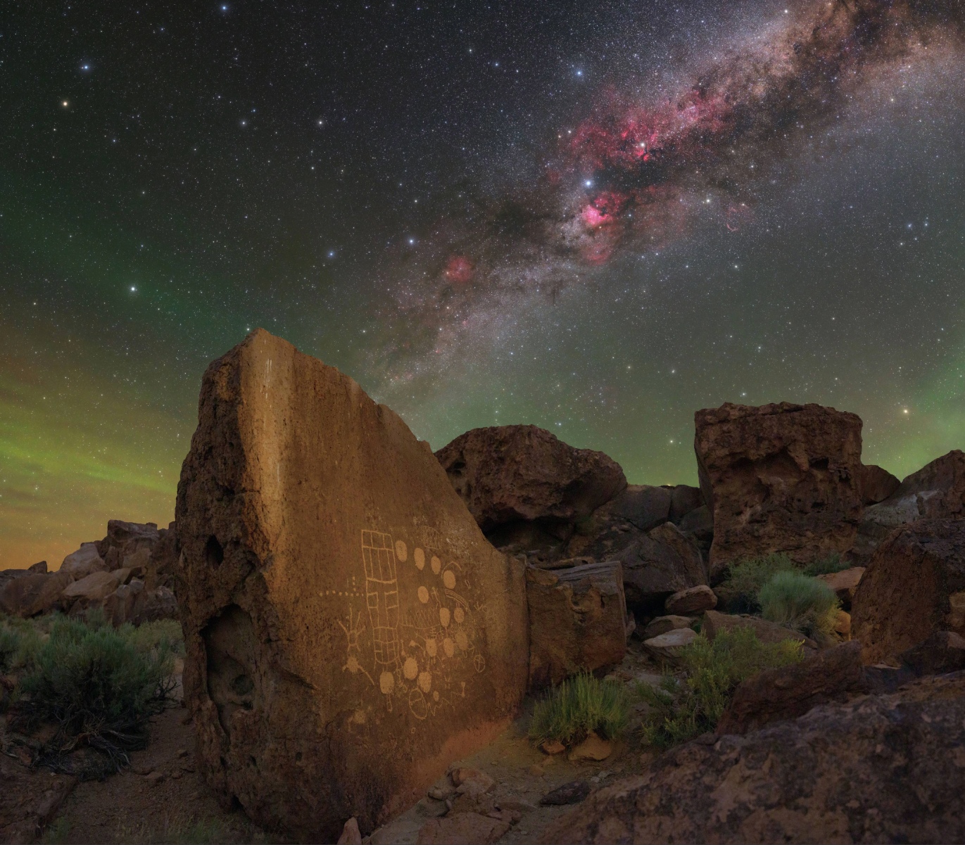 An ancient rock with engravings on it and a dark sky with stars lit up