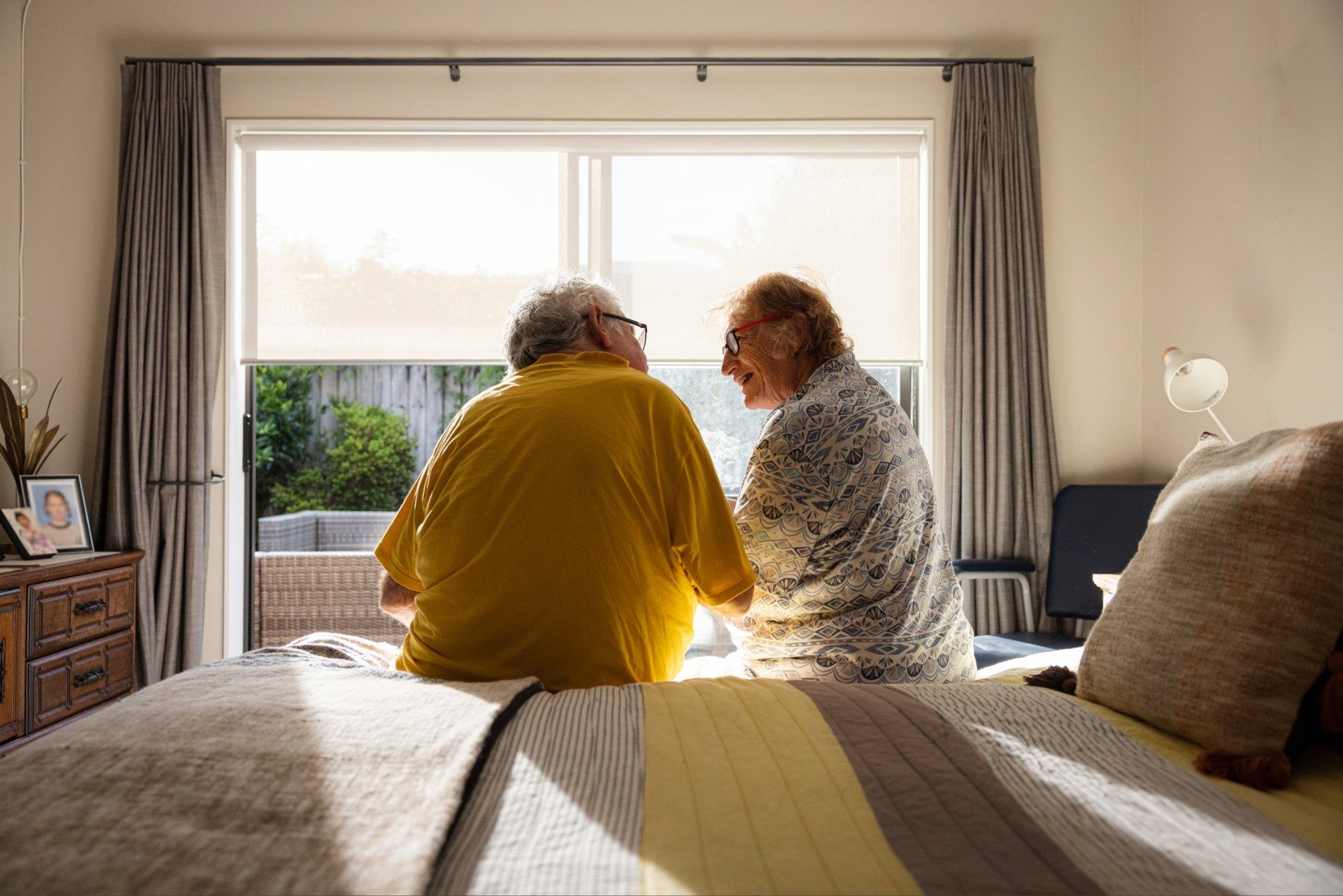 Elderly couple sitting on a bed