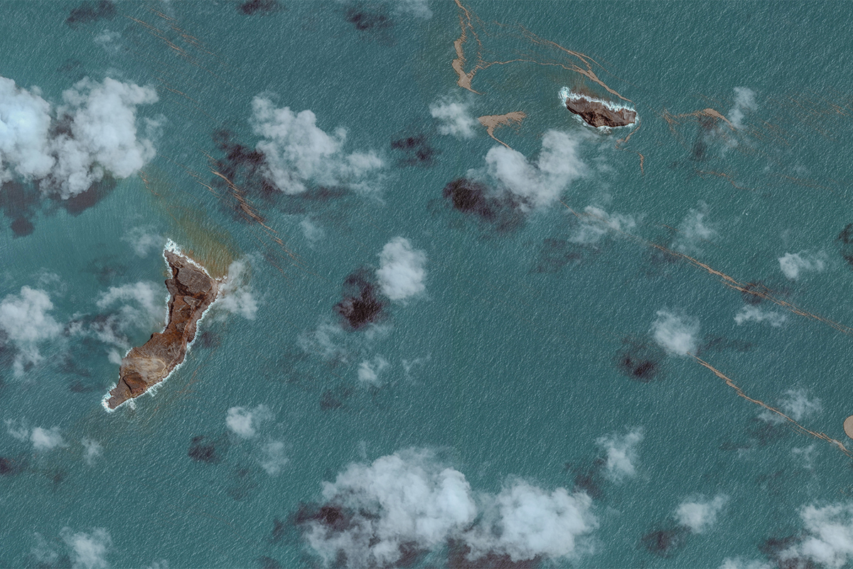 Aerial view of green blue water and two small islands.