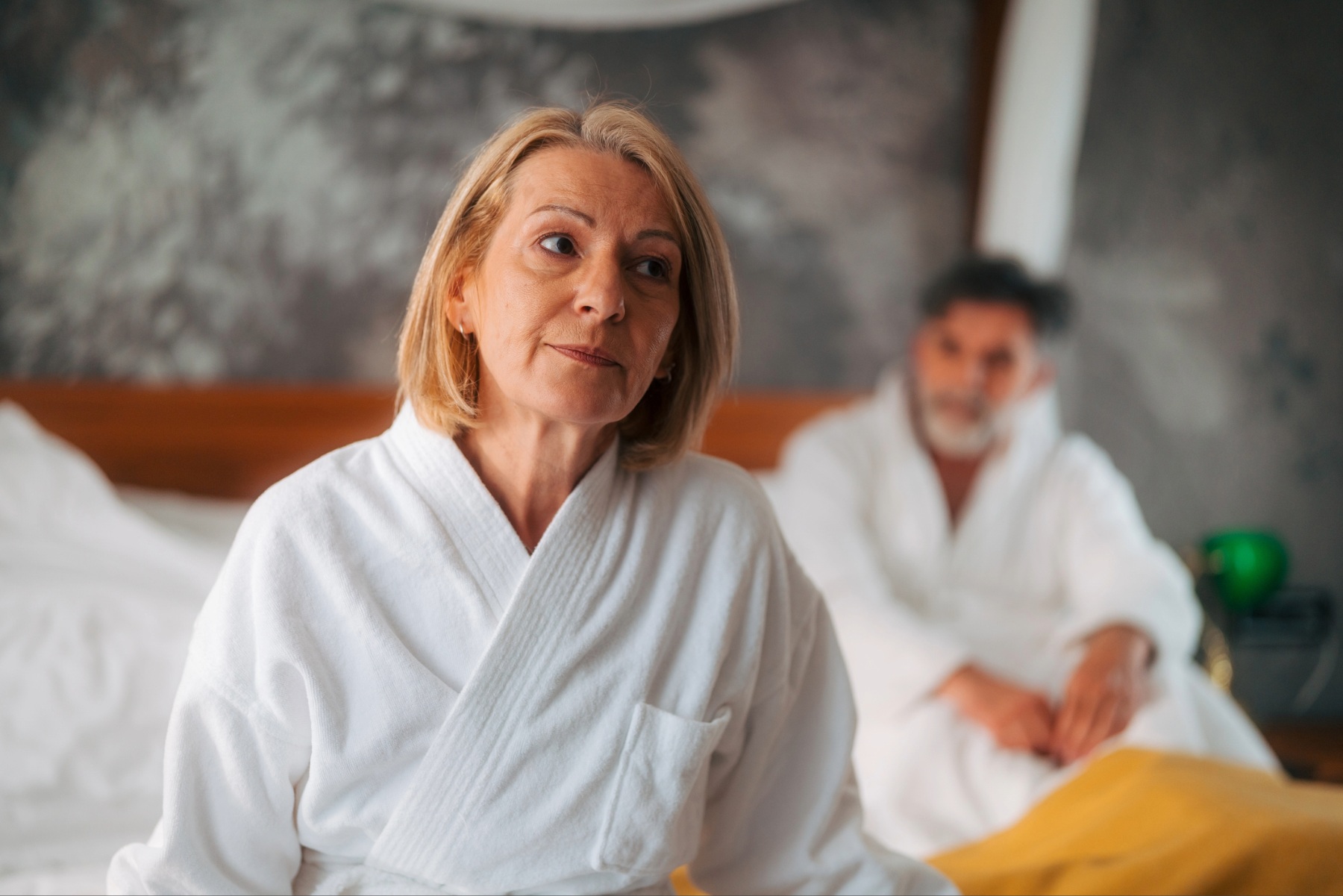 Mature woman looking away, sitting separated from partner