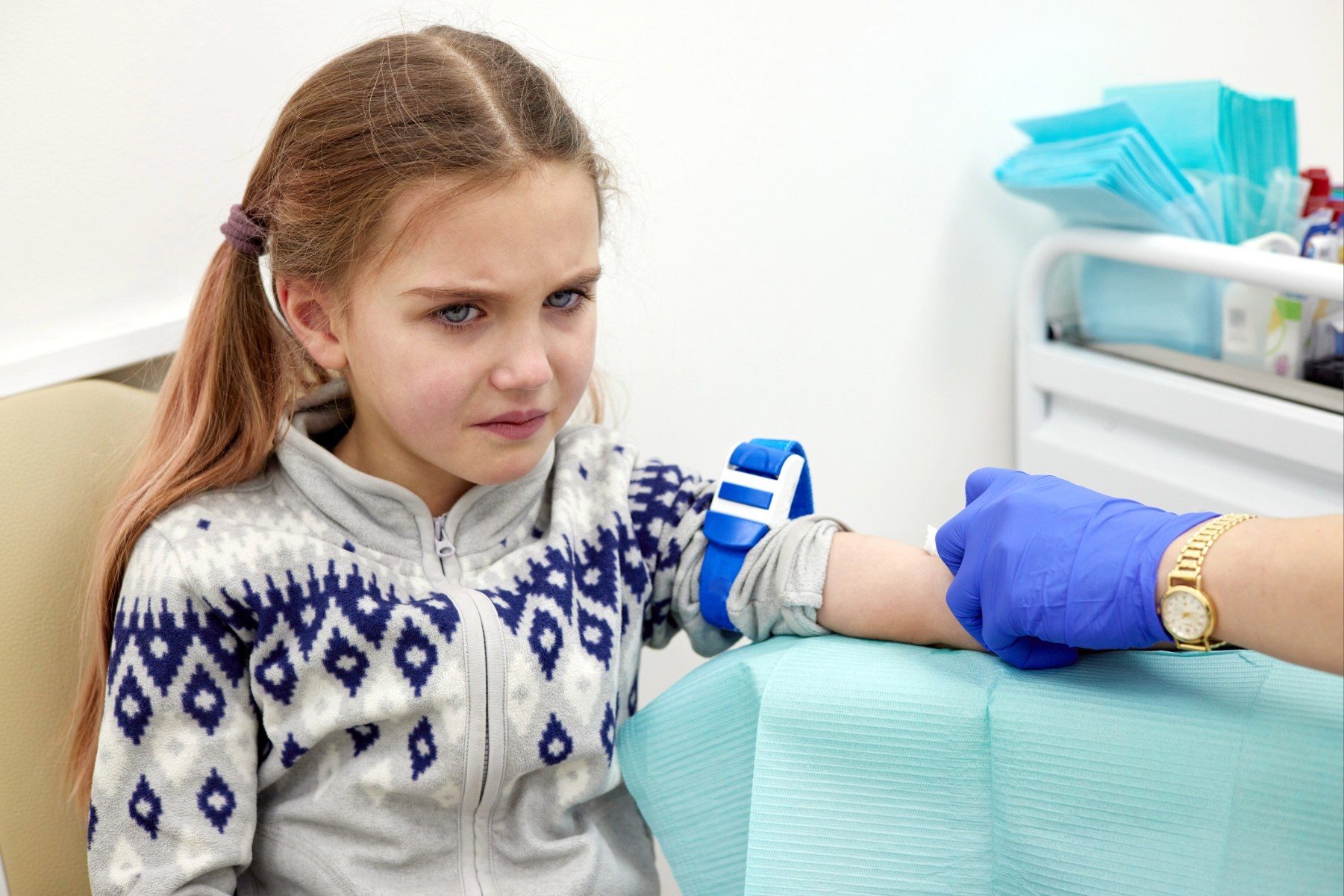 Unhappy young girl having her blood drawn