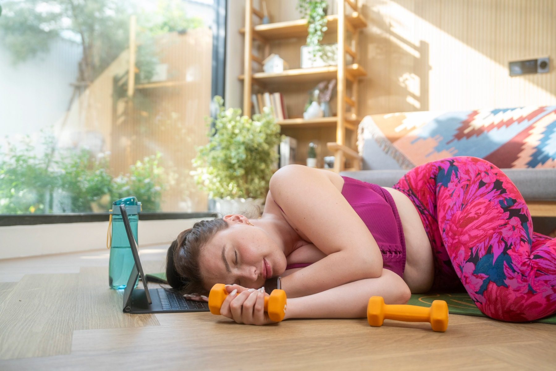 Woman in workout gear sleeping on the floor