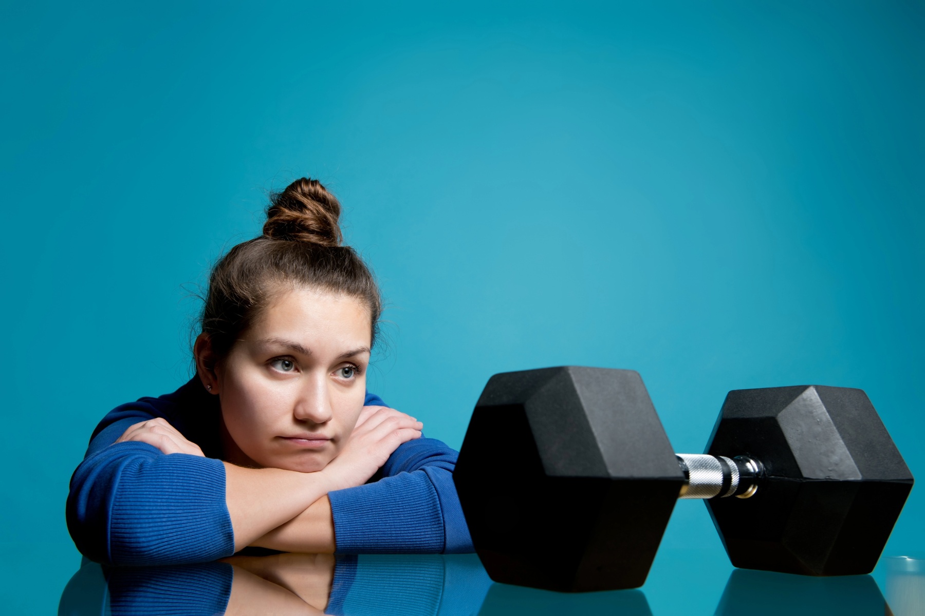 Woman looking at dumbbell