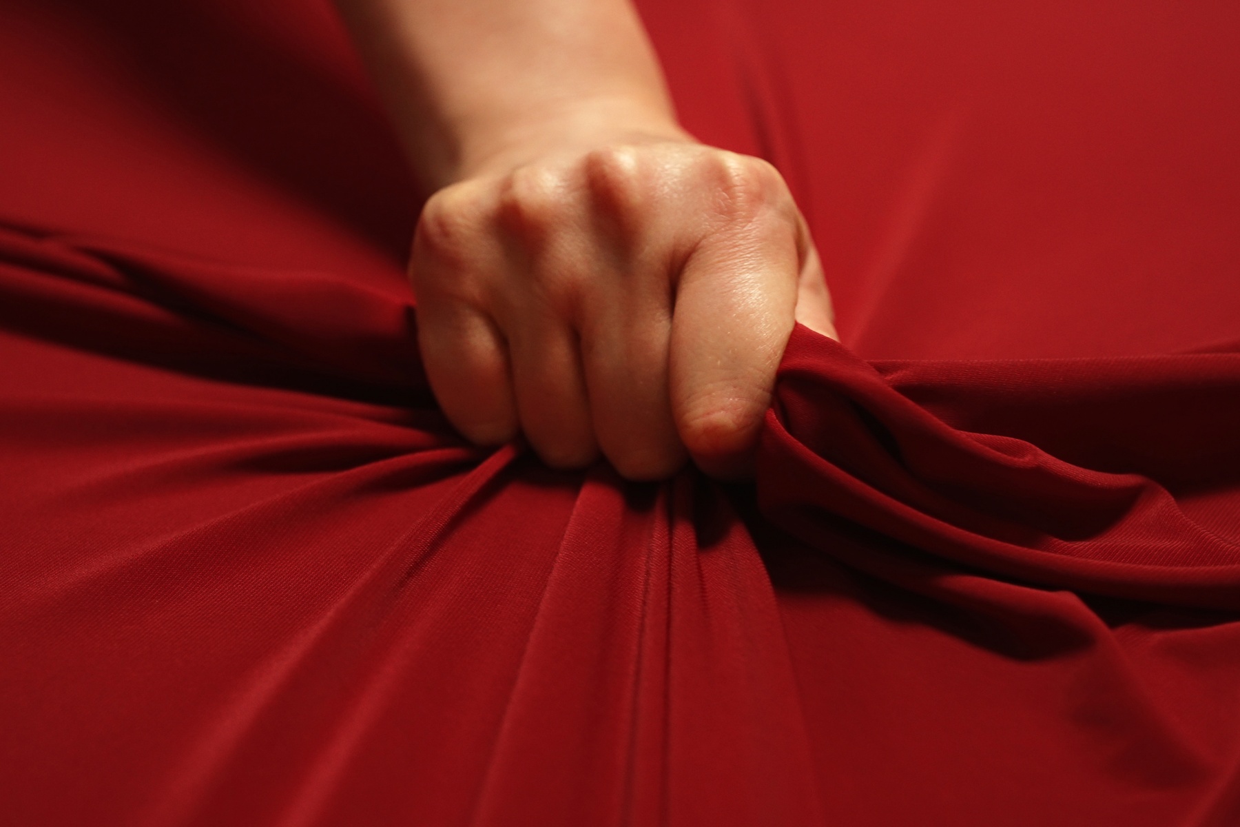 Hand grabbing bed sheets