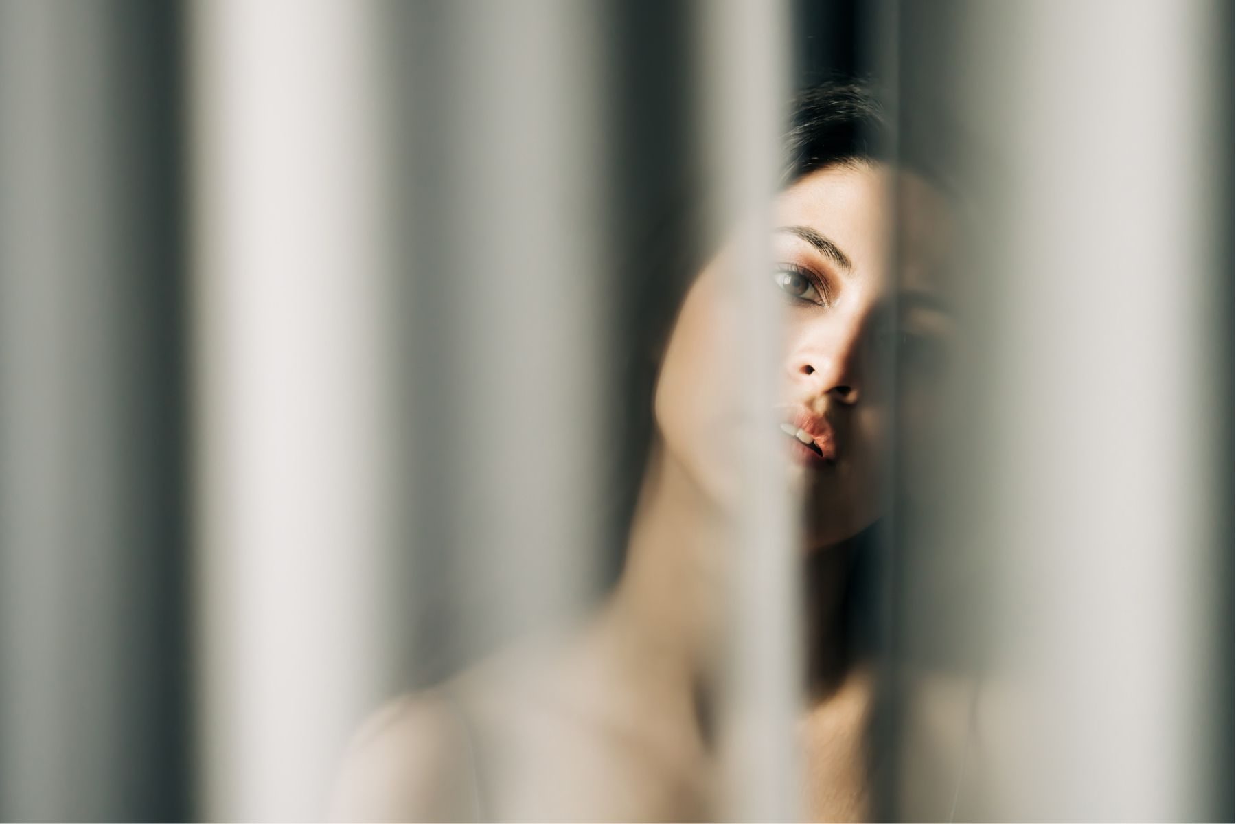 Woman hiding behind a blind