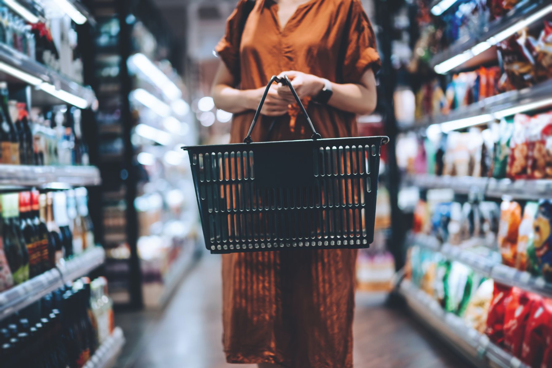 A woman in a supermarket holding a shopping basket