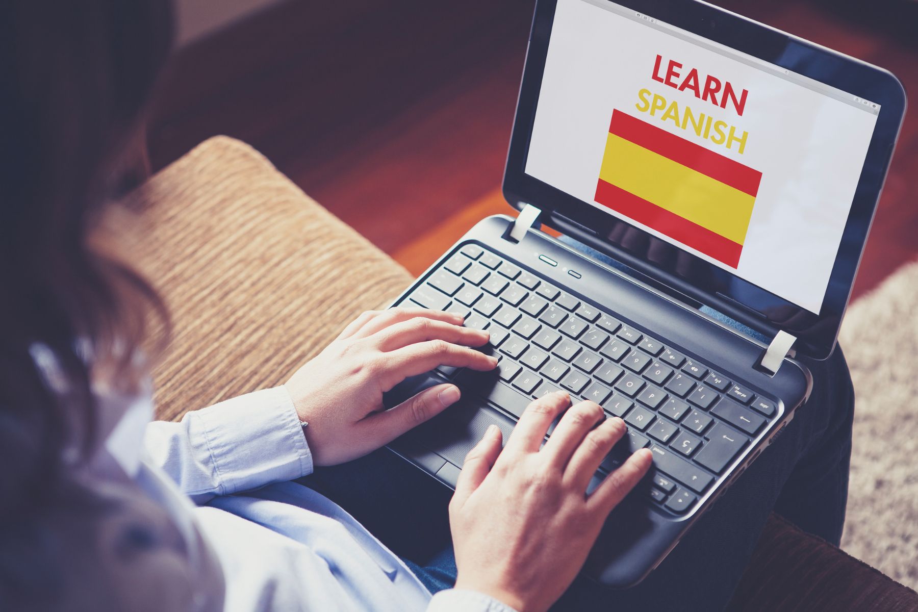 Someone sits at their computer, ready to learn Spanish