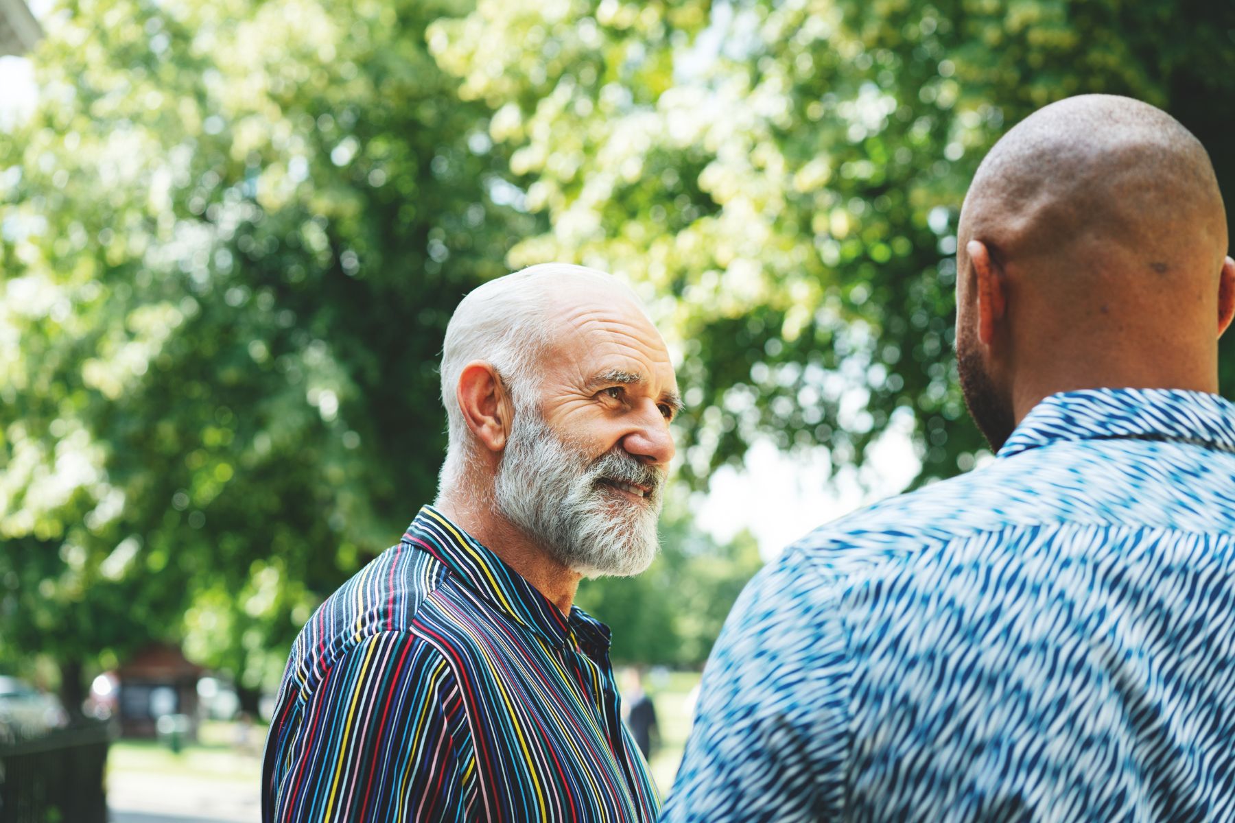 Two men talk with one another outside